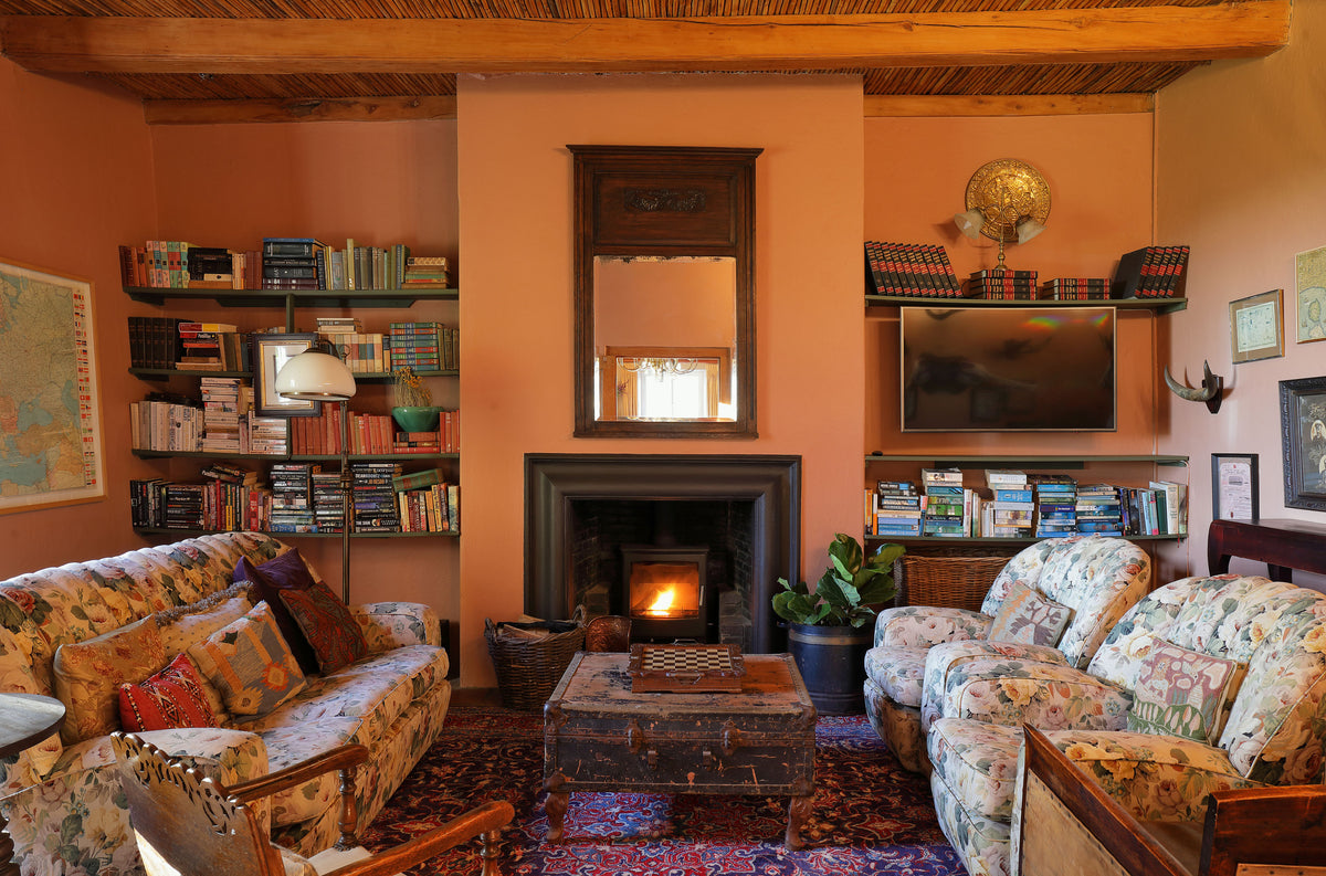 Manor House lounge with high ceilings and an original fireplace